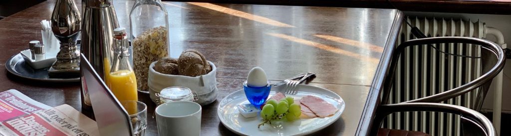 Frukost tallrik med ägg, vindruvor och skinka.