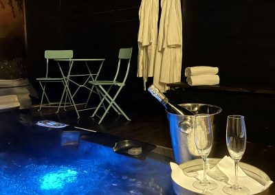oöppnad champagne flask med två glas vid jacuzzi
