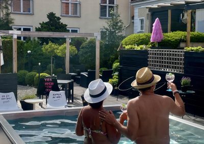 Två gäster njuter av drinkar i poolen